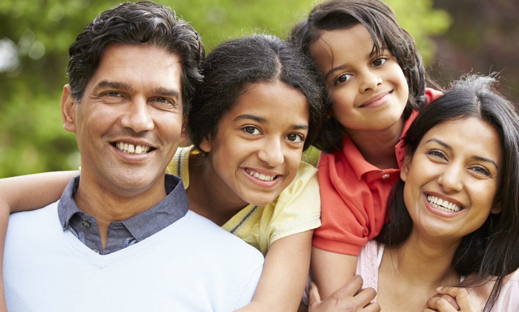 Non-white family with two children smiling