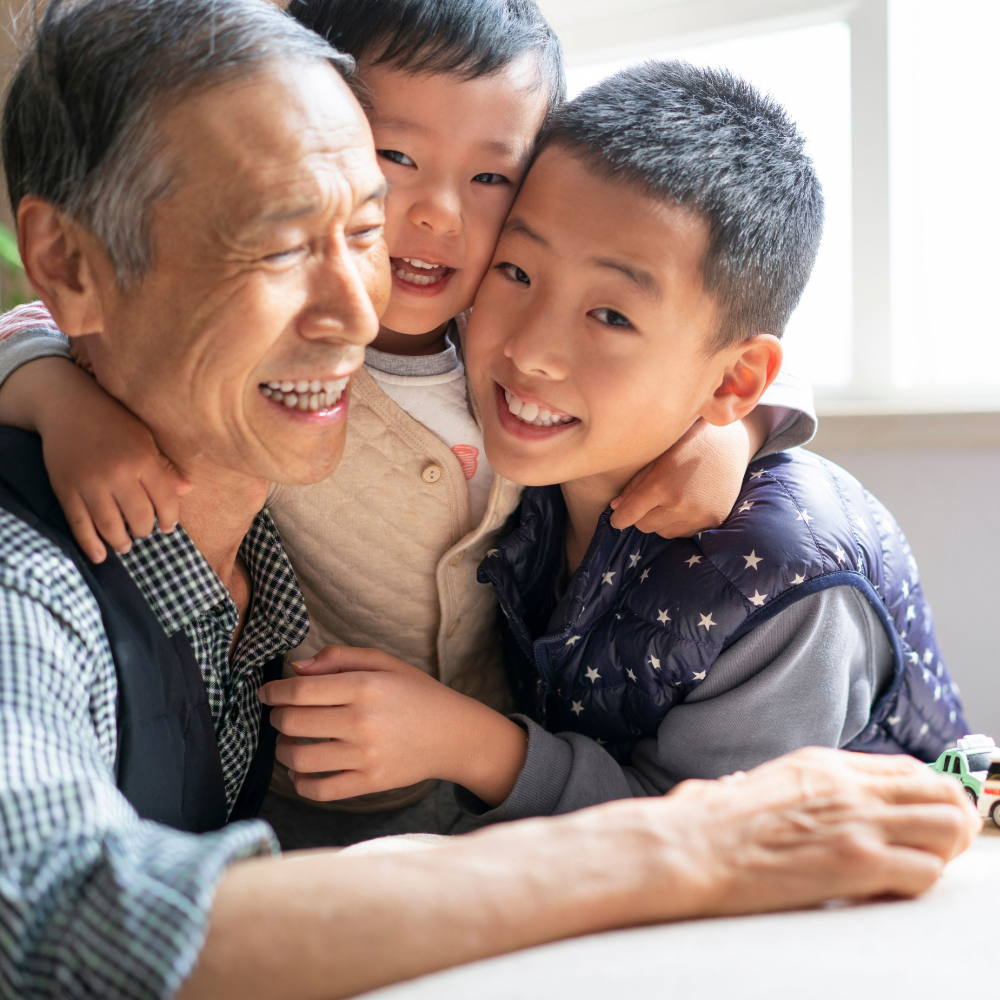 Grandfather and his two grand children smiling.