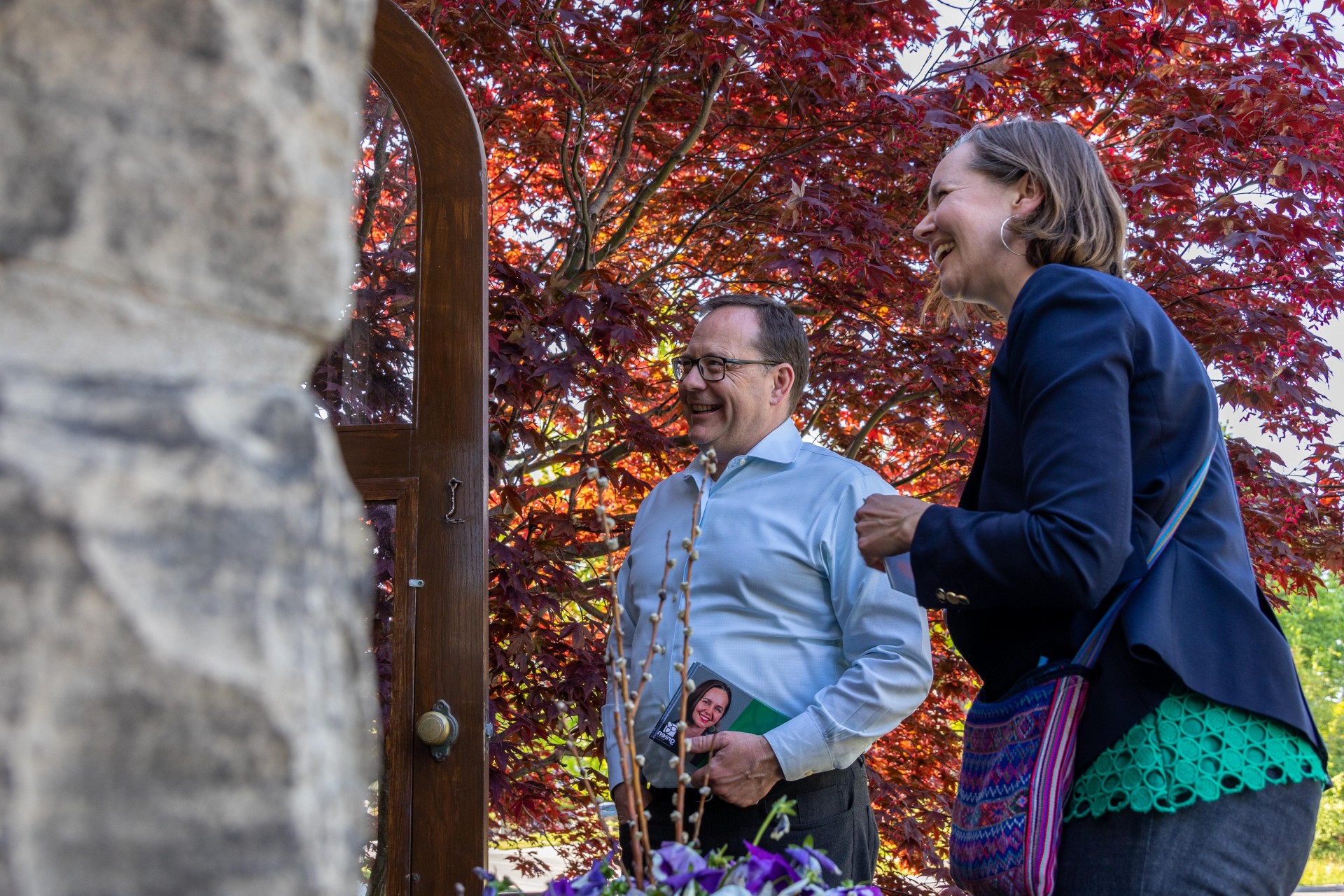 Mike Schreiner and Aislinn Clancy speaking to someone at their door