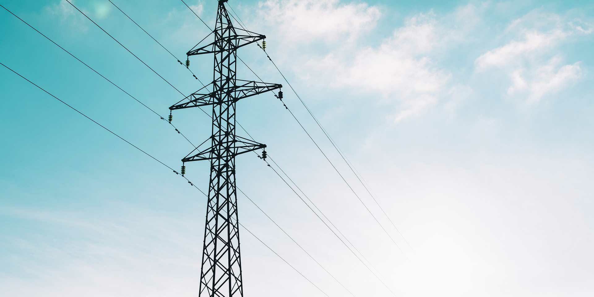 Electric tower and power lines under blue sky