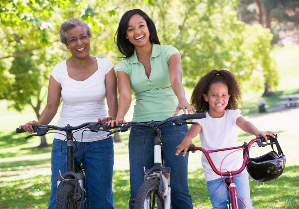 Grandmother with adult daughter and grandchild riding bikes