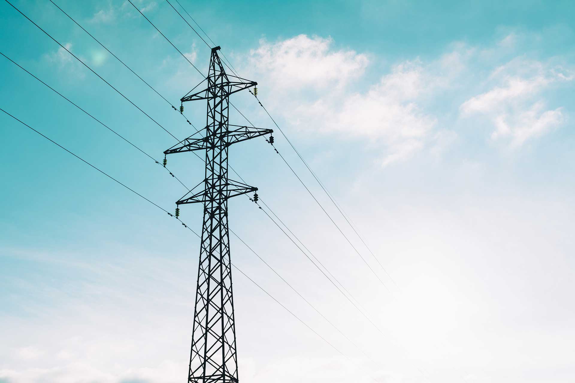 Electric tower and power lines under blue sky