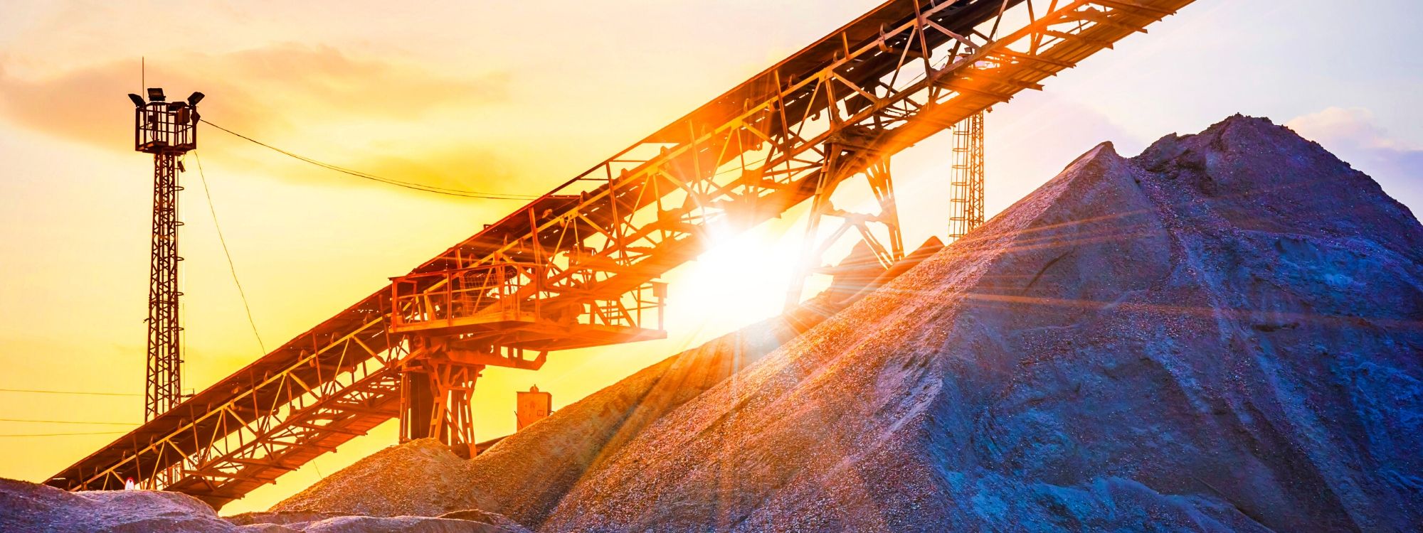 Mining crane and slag heap at sunset